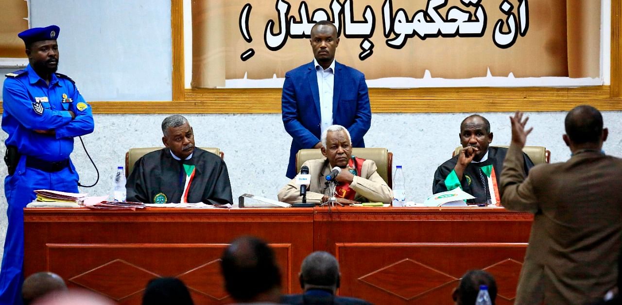 Judge Issam al-Din Mohammad Ibrahim (C) presides over a hearing in the trial of Sudan's ousted president Omar al-Bashir (unseen) and 27 co-accused over the 1989 military coup that brought him to power. Credit: AFP Photo