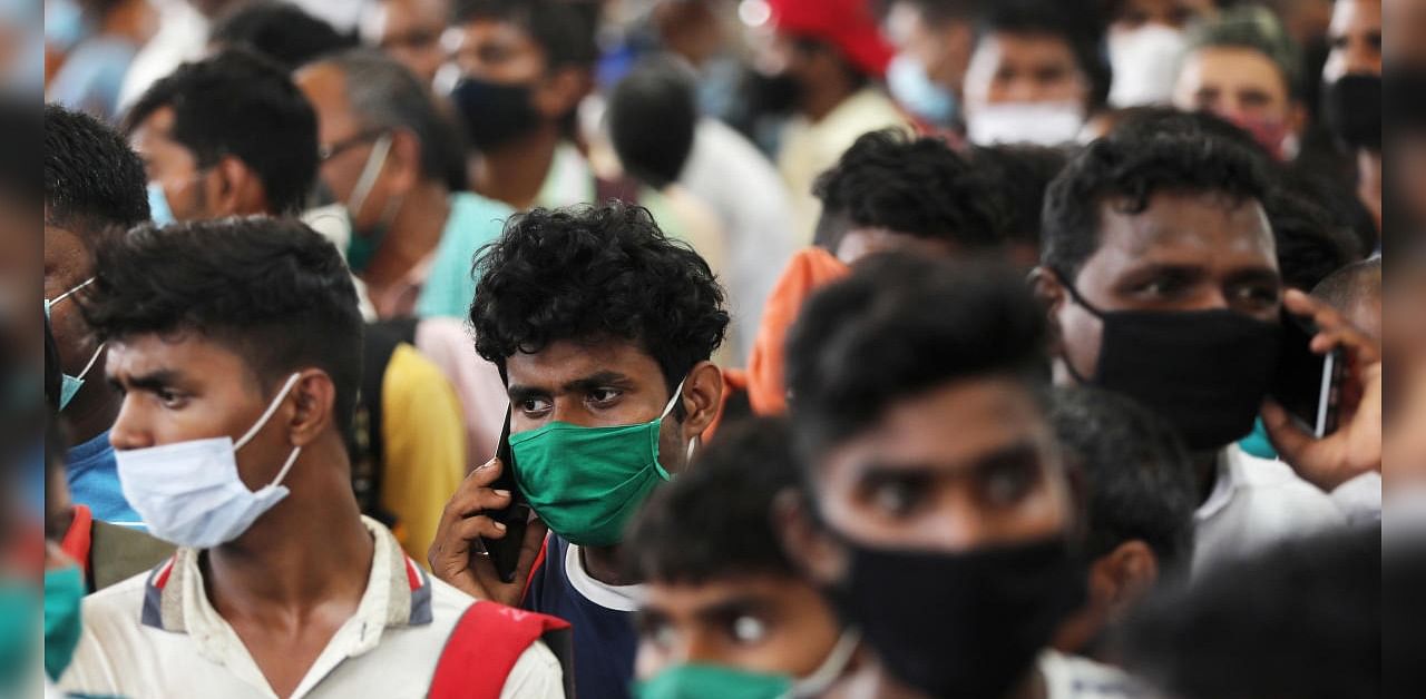 Migrants who returned from their hometown of Uttar Pradesh wait in line to be tested for the coronavirus disease during a rapid antigen testing campaign at a railway station, on the outskirts of Mumbai. Credit: Reuters Photo