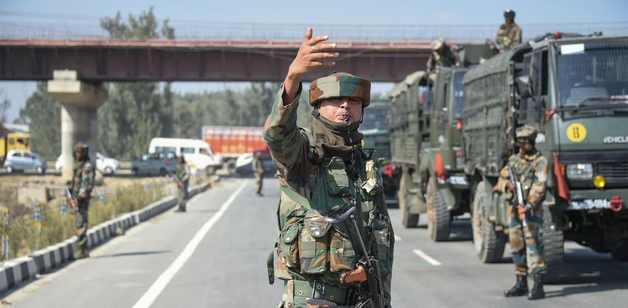 A CRPF personnel stands guard as army convoy moves towards the site of a militant attack on Srinagar-Jammu National highway at Pampore, in Pulwama District of South Kashmir, Monday, Oct. 5, 2020. Credit: PTI Photo