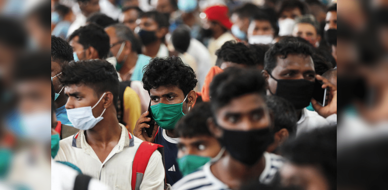 Migrants who returned from their hometown of Uttar Pradesh wait in line to be tested for the coronavirus disease during a rapid antigen testing campaign at a railway station, on the outskirts of Mumbai, India, October, 3, 2020. Credit: Reuters Photo