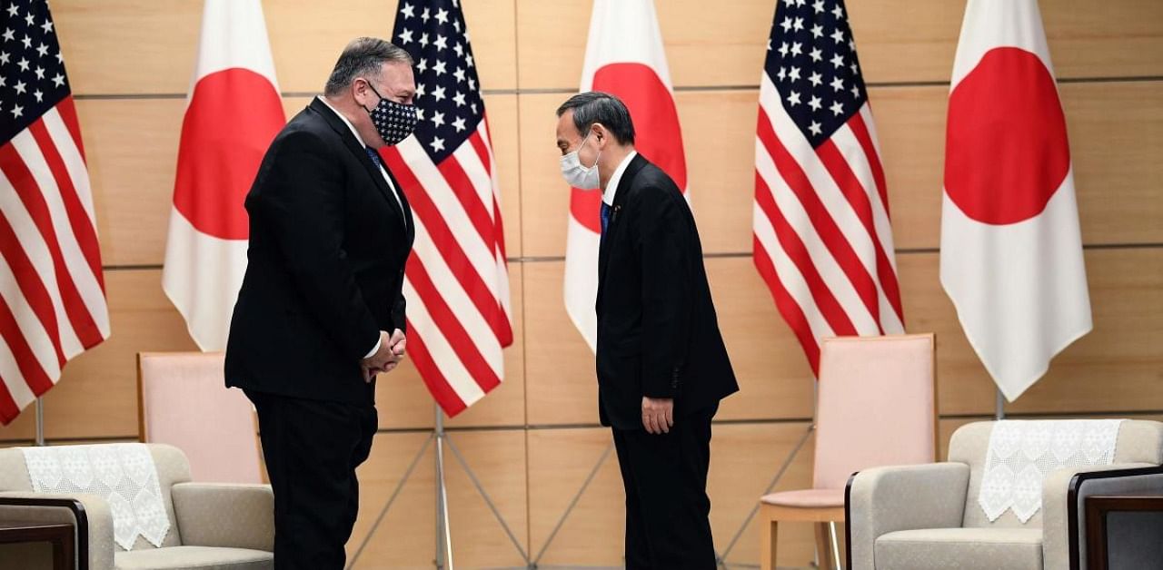 Japan's Prime Minister Yoshihide Suga (R) and US Secretary of State Mike Pompeo (L) bow as they attend a meeting at the prime minister's office in Tokyo. Credit: AFP