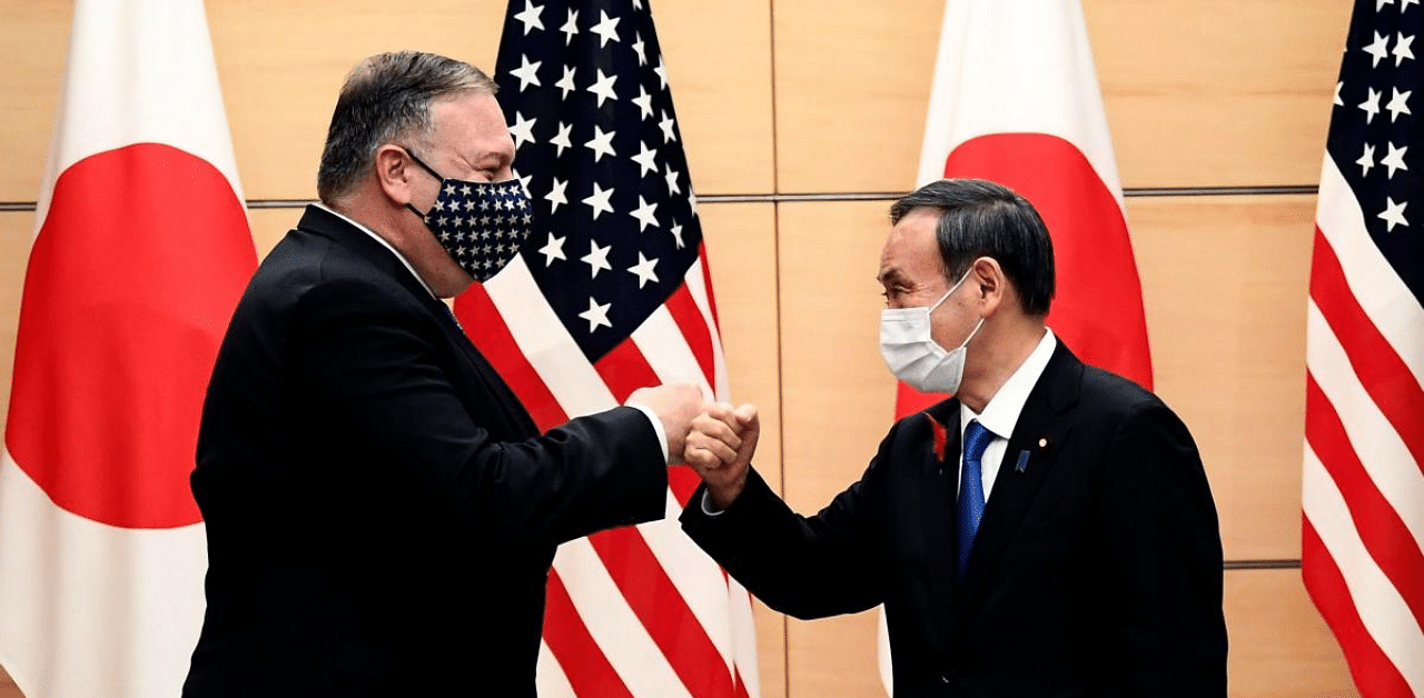 Japan's Prime Minister Yoshihide Suga (R) and US Secretary of State Mike Pompeo (L) bump fists as they meet at the prime minister's office in Tokyo. Credit: AFP Photo