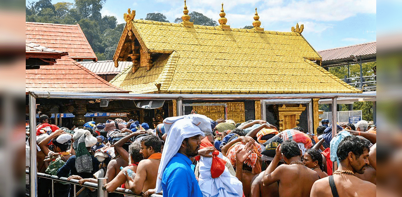 Devotees stand in a queue to offer their prayers at the Lord Ayyappa temple in Sabarimala. Credits: PTI Photo