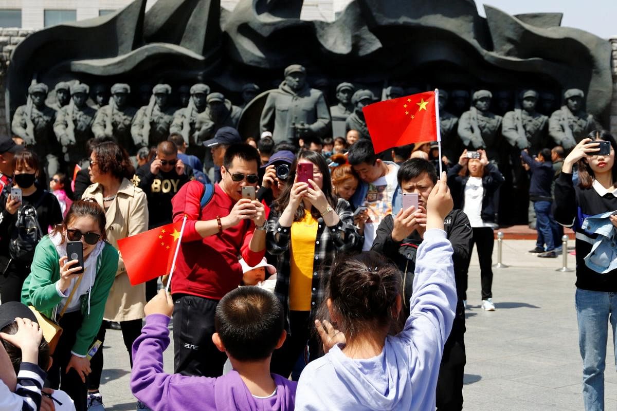 Chinese tourists last year in the city of Dandong, near statues of soldiers who took part in the Korean War. Reuters