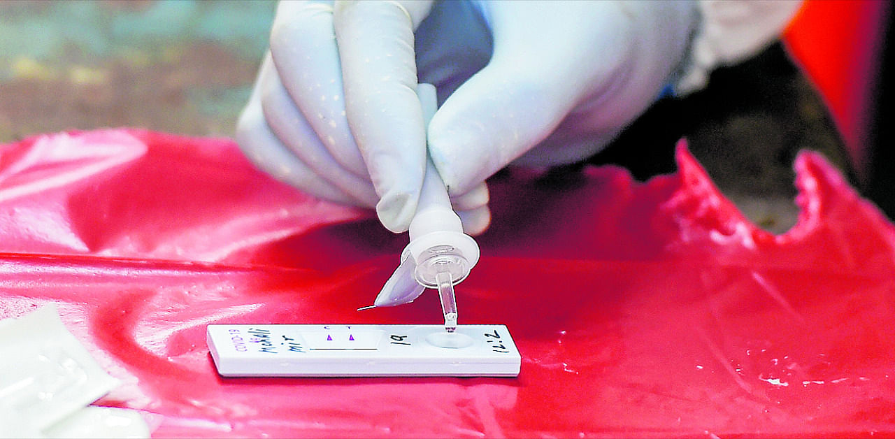 A health worker collects a sample via Rapid Antigen kit for Covid-19 test, during Unlock 3.0, at Deonar in Mumbai. Credit: PTI Photo
