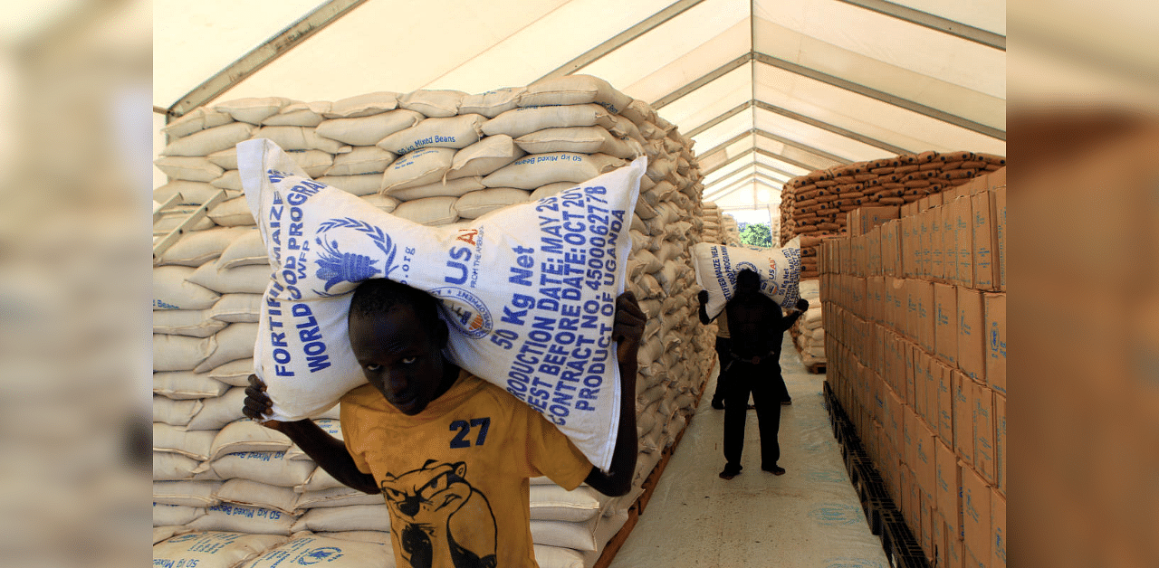 People carry sacks of dry food rations from the World Food Programme (WFP) store, for distribution to South Sudanese refugees, at the Palabek Refugee Settlement Camp in Lamwo district, Uganda June 16, 2017.  Credit: Reuters File Photo