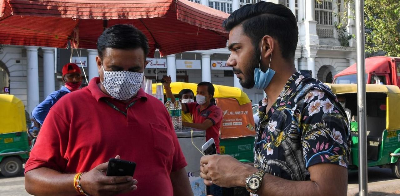 A man who was walking in market without a lowered facemask, violating preventive measures against the spread of coronavirus, at Connaught Place in New Delhi. Credit: AFP