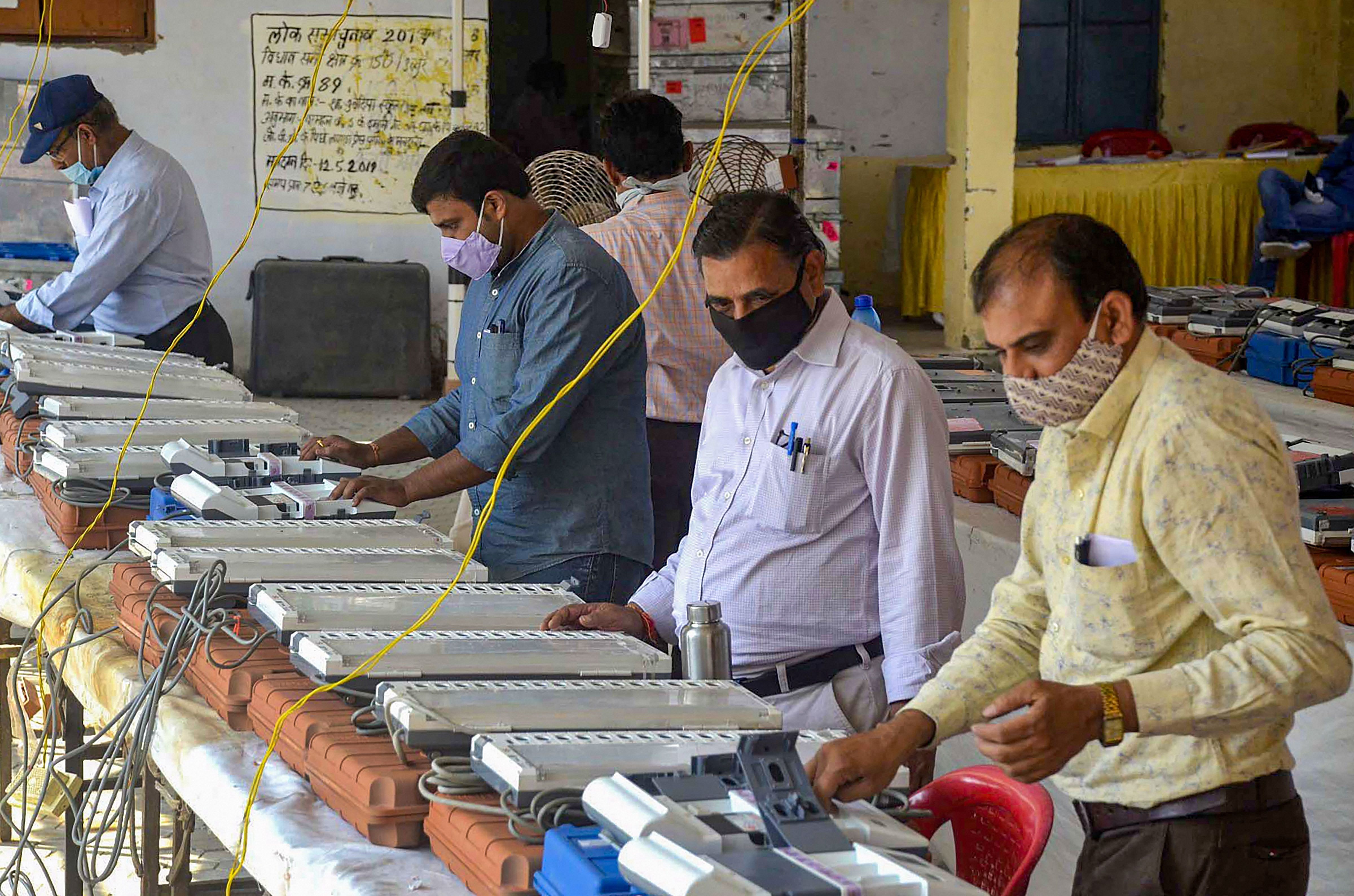Poll officials check Electronic Voting Machines (EVMs). Credits: PTI Photo