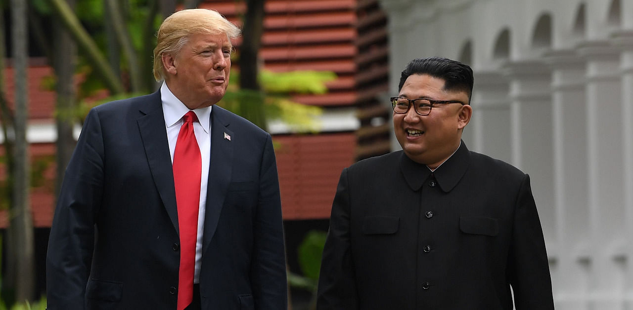 North Korea's leader Kim Jong Un (R) walks with US President Donald Trump (L) during a break in talks at their historic US-North Korea summit, at the Capella Hotel on Sentosa island in Singapore. Credit: AFP File Photo