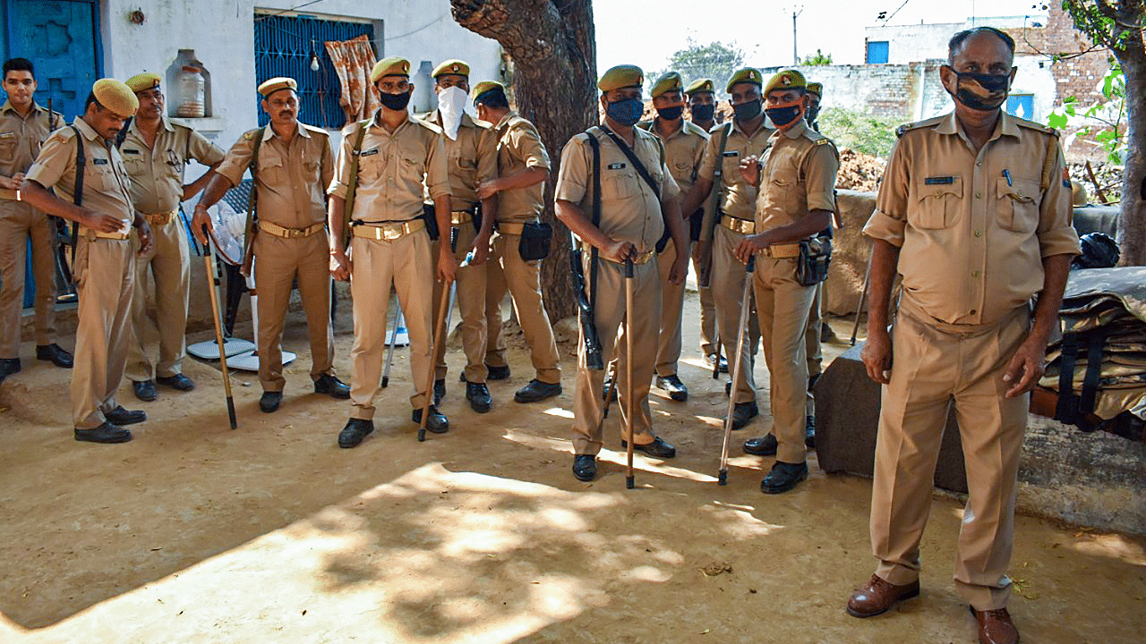 Police personnel stand guard outside the residence of a 19-year-old Dalit woman who died after being allegedly gang-raped. Credits: PTI Photo