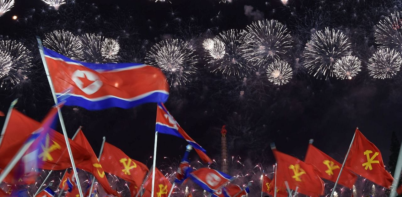 People wave North Korean flags beneathe a fireworks display during commemorations of the 75th anniversary of the founding of the ruling Workers' Party of Korea. Credit: Reuters Photo