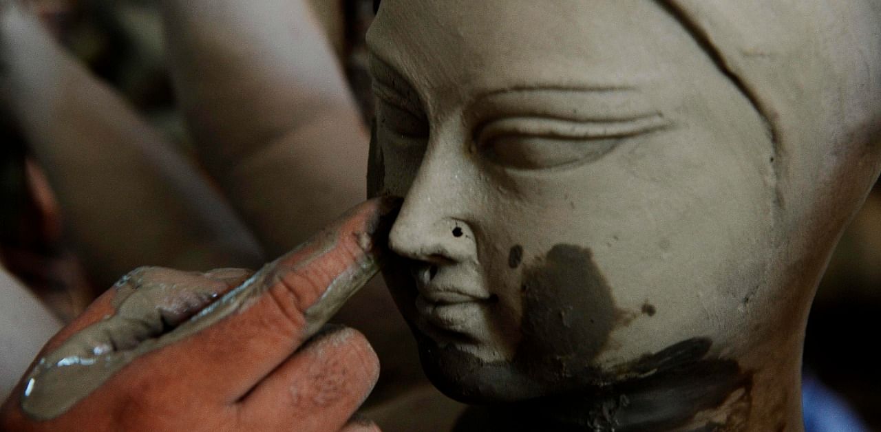 An artisan works on clay sculptures depicting a Hindu goddess ahead of the upcoming 'Durga puja' festival. Credit: AFP Photo