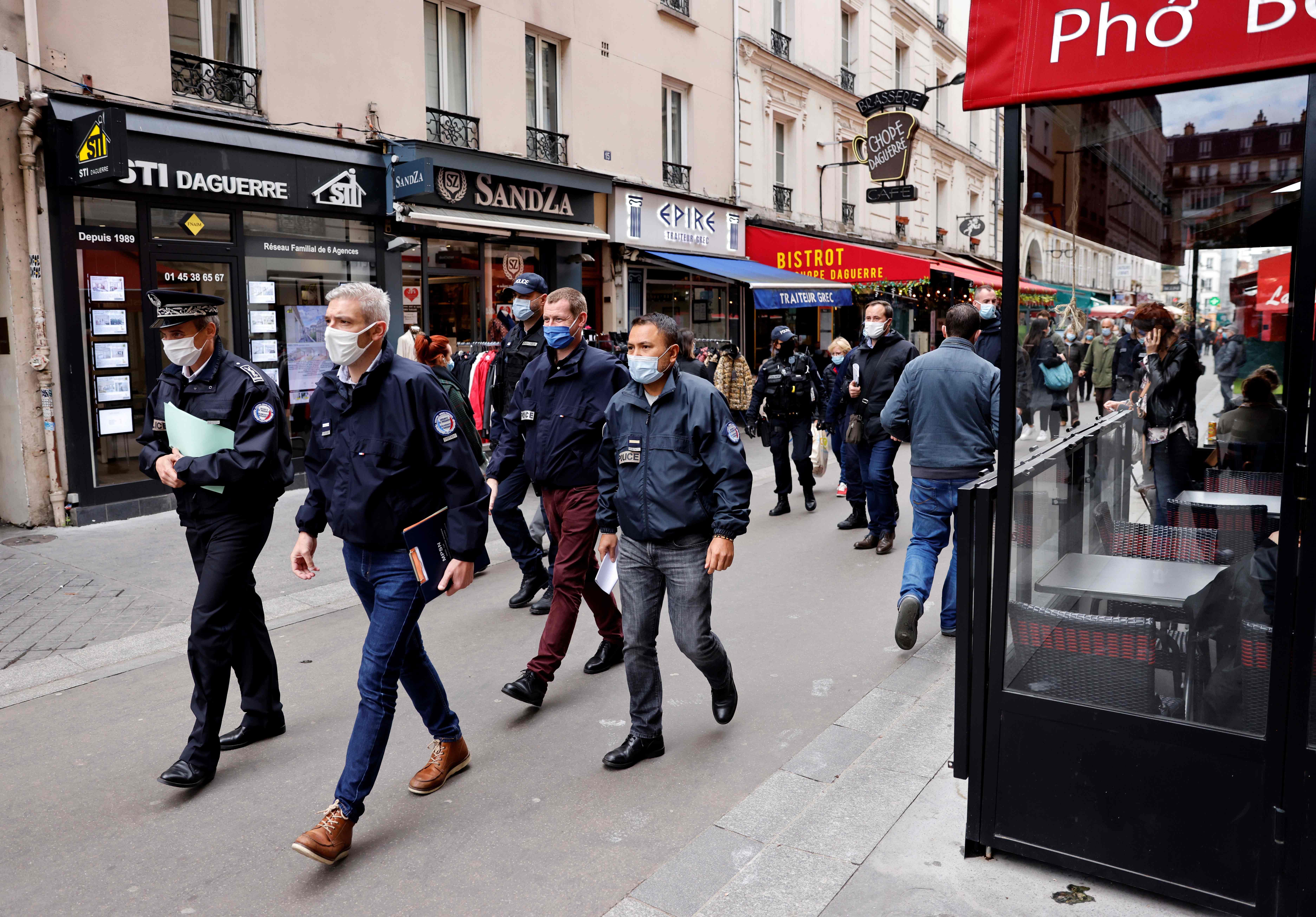 Police officers walk in a street with restaurants in Paris. Credits: AFP Photo
