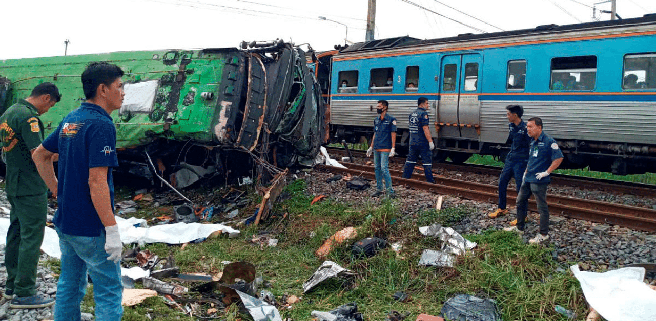 Rescue workers stand at the crash site where a train collided with a paseengers bus in Chacheongsao province in central Thailand. Credit: Reuters Photo 