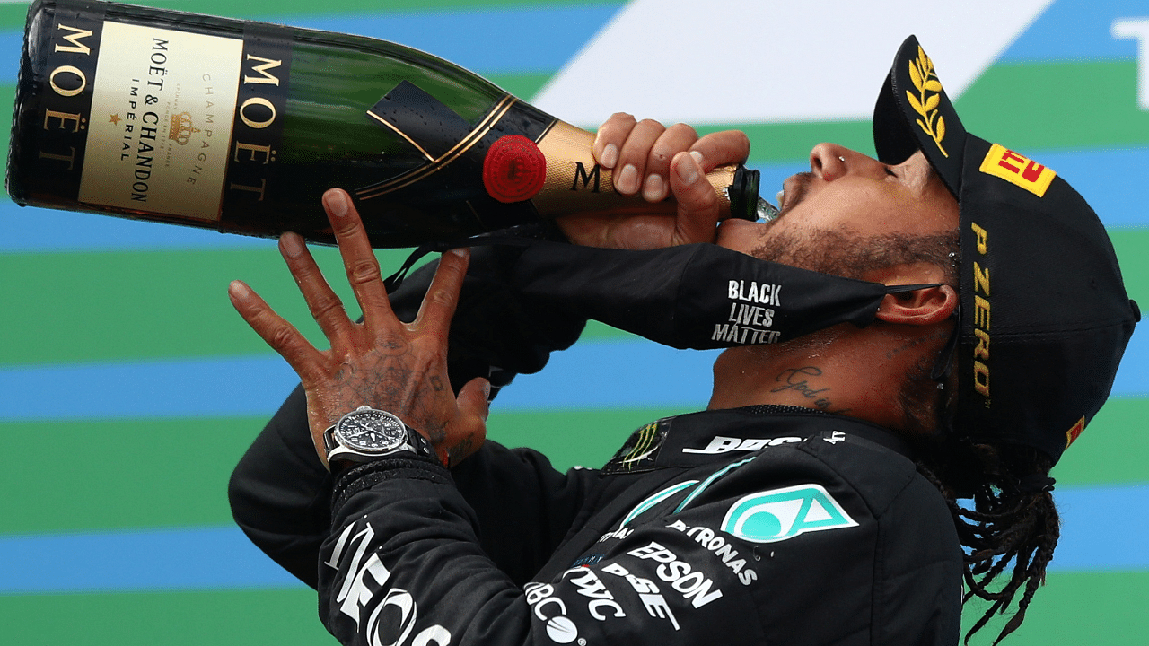 Mercedes' Lewis Hamilton celebrates with sparkling wine on the podium after winning the race Pool. Credits: Reuters Photo