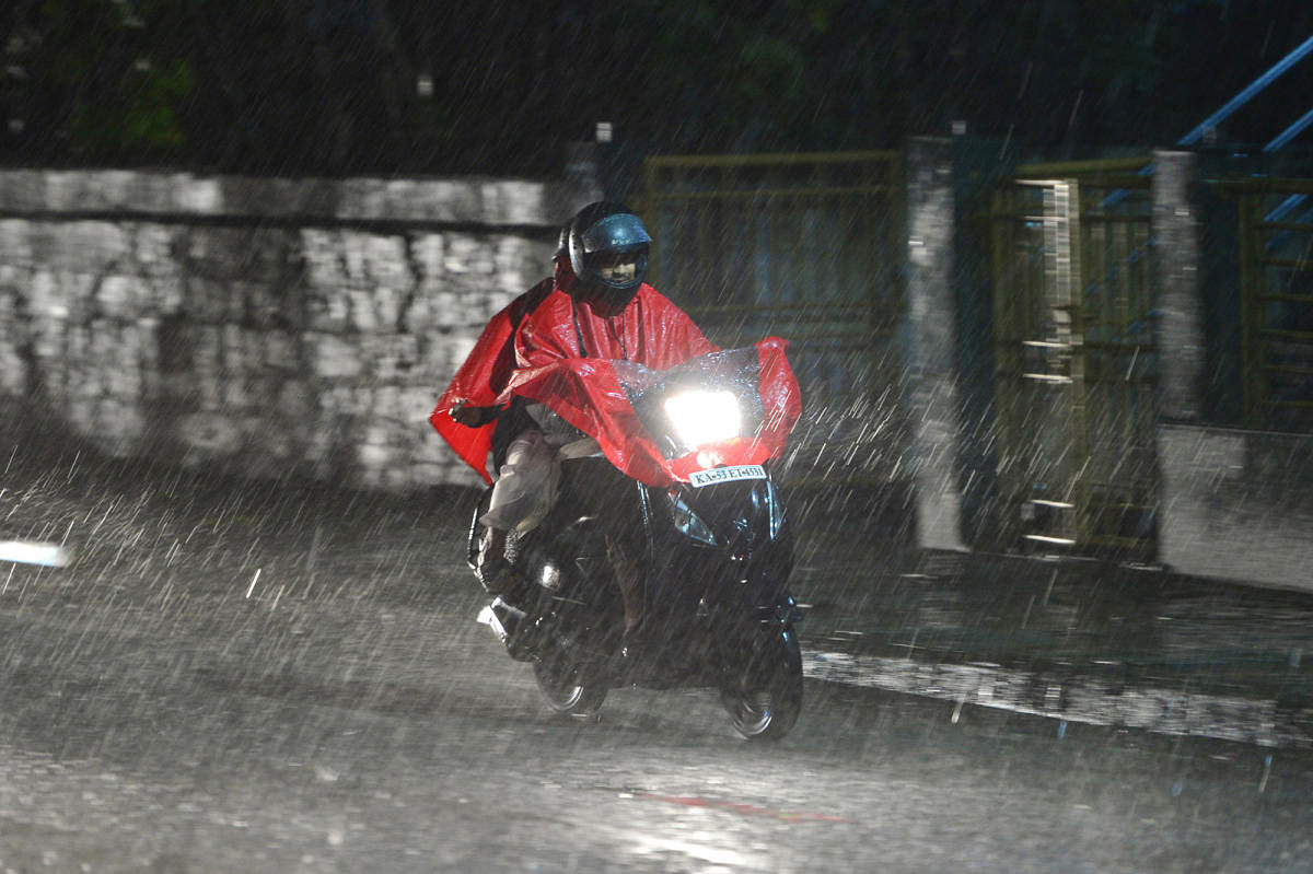 A motorcyclist rides on a rain-filled road near the Bengaluru Cantonment railway station on Saturday. DH PHOTO/M S MANJUNATH