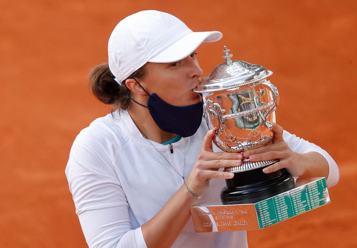 Poland's Iga Swiatek kisses the trophy as she celebrates after winning the French Open. Credit: REUTERS