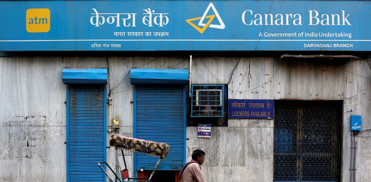 A rickshaw puller passes the Canara Bank branch in the old quarters of Delhi, India. Credit: Reuters Photo