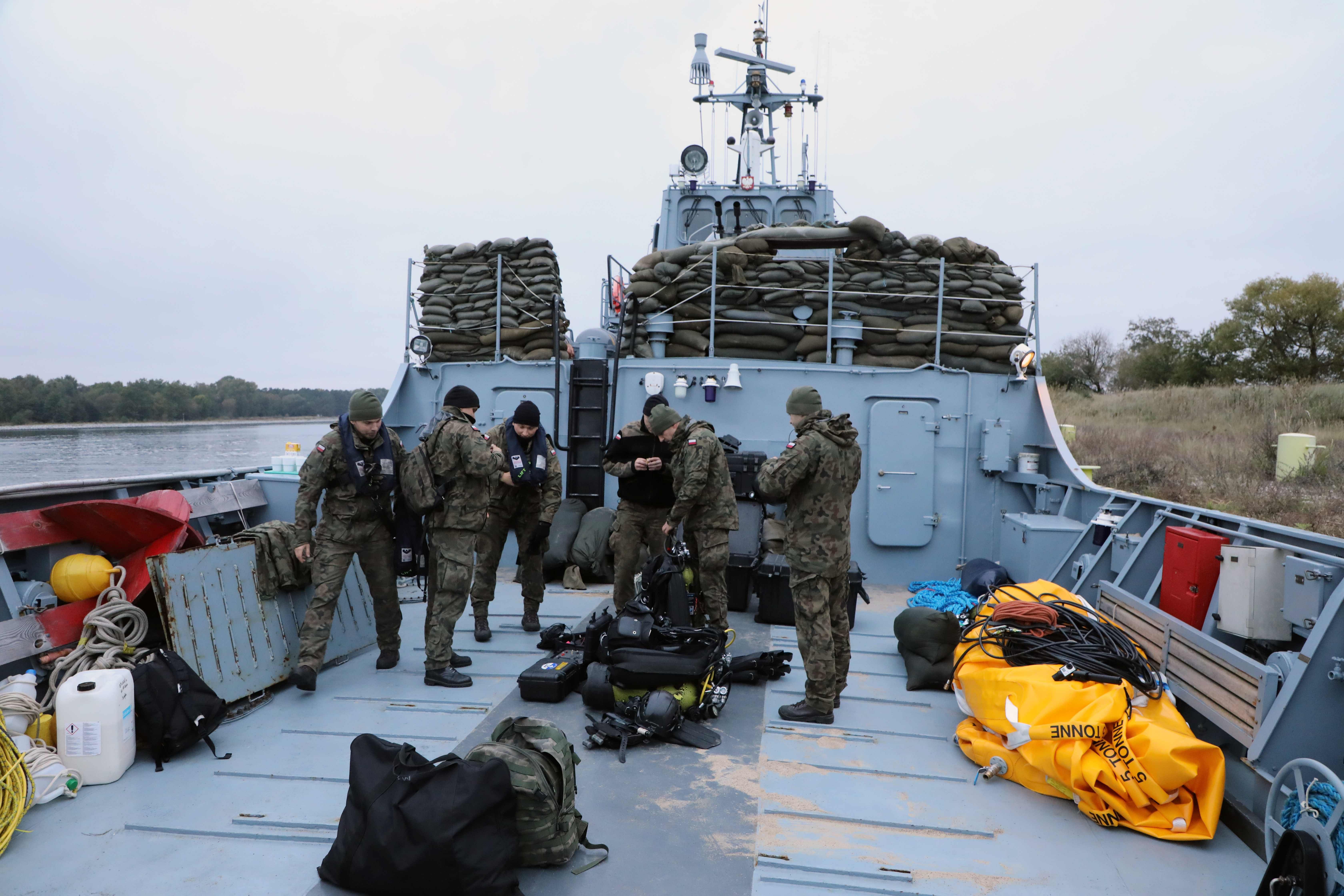 Polish Navy divers prepare the equipment to be used in the operation to defuse a WWII five-tonne underwater bomb derelict (also known as an "earthquake bomb"), in Piast, a shipping channel near the island of Karsibor, south of the city of Swinoujscie, Poland, on October 12, 2020. - Hundreds of residents were evacuated on October 12, 2020, as Polish military divers began a high-risk operation to defuse a British WWII 'Tallboy' bomb dropped by the Royal Air Force in an attack on a Nazi warship in 1945, discovered in a channel near the Baltic Sea. Credit: AFP