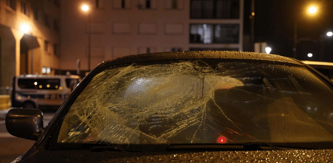 A car with a broken windshield is parked in front of the police station of Champigny-sur-Marne, outside Paris, on October 11, 2020, on the evening after it was attacked by around 40 people launching fireworks. Credit: AFP Photo