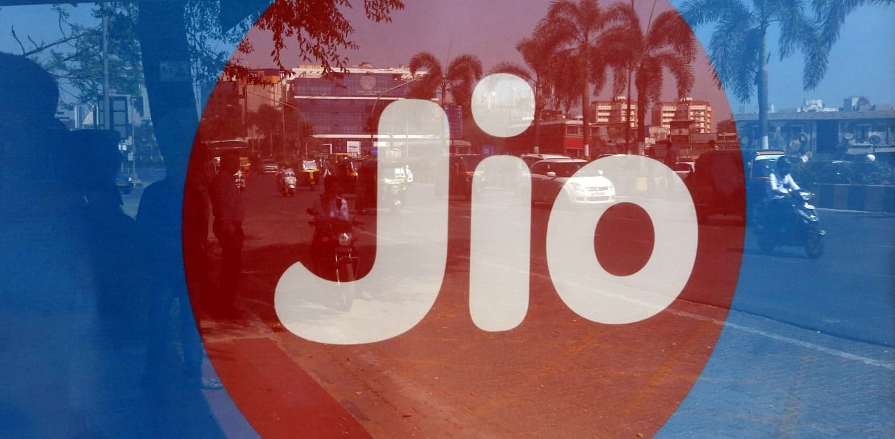 Commuters are reflected on an advertisement of Reliance Industries' Jio telecoms unit. Credit: Reuters Photo