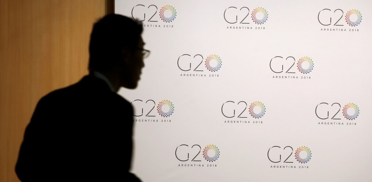 A man stands next to a board with the G20 Meeting of Finance Ministers logo in Buenos Aires. Credit: Reuters Photo