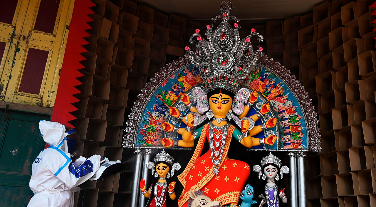 A man in a personal protective equipment (PPE) suit sanitises an idol of the Hindu goddess Durga ahead of the upcoming 'Durga Puja' festival, in Kolkata on October 13, 2020. Credit: AFP Photo