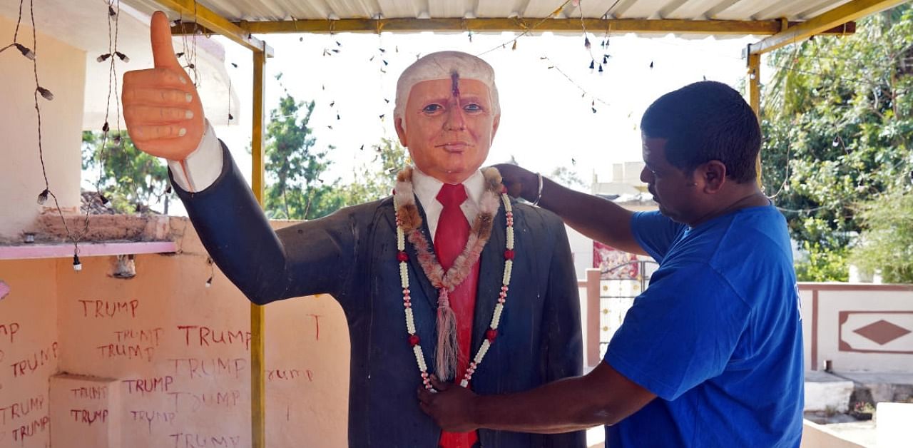 Bussa Krishna, a fan of US President Donald Trump, adjusts a garland on a Trump statue after offering prayers at his house in Konney village in the southern state of Telangana, India. Credit: Reuters