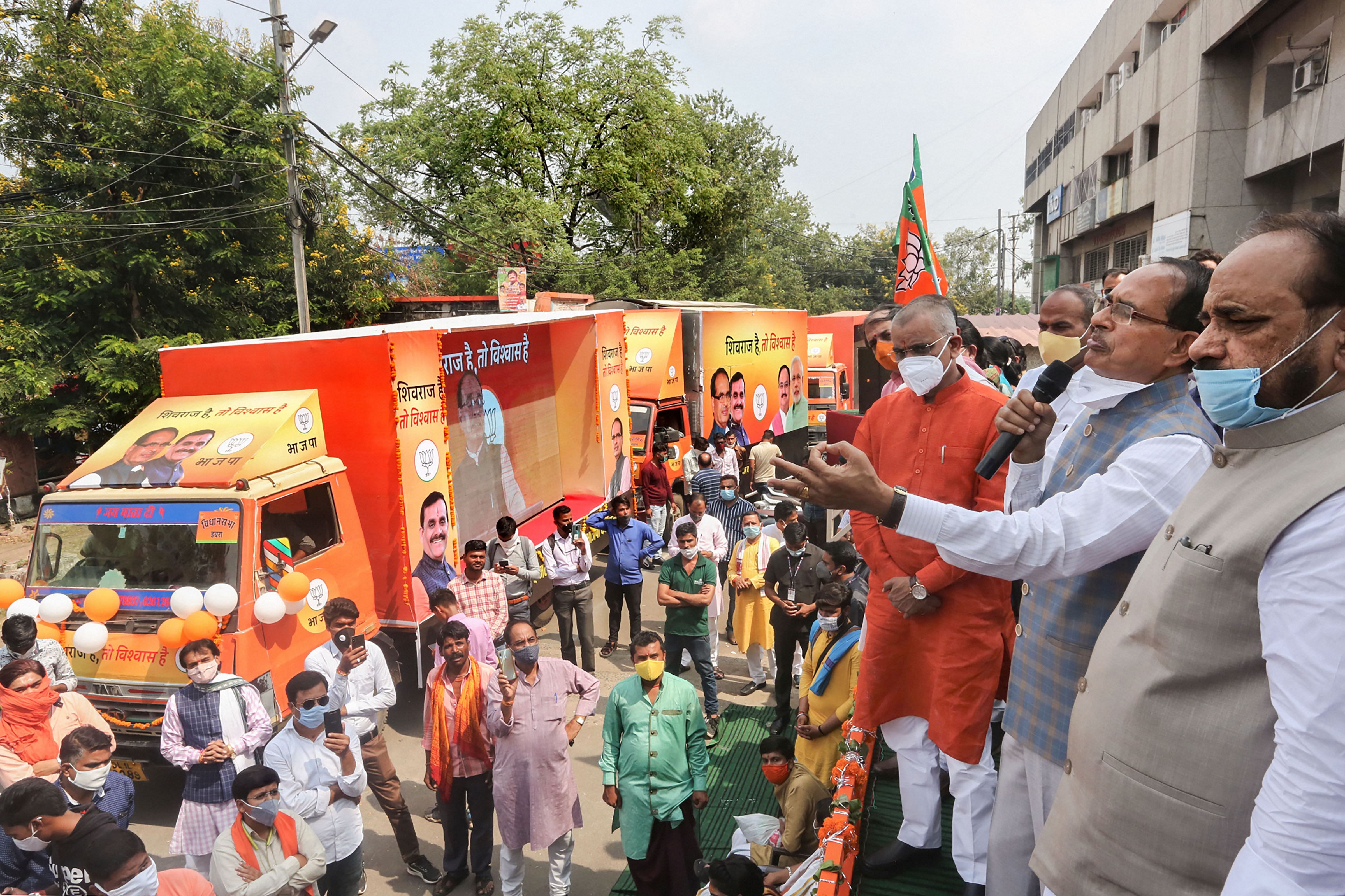 Madhya Pradesh Chief Minister Shivraj Singh Chouhan with BJP State President VD Sharma flags of digital election campaign vehicles for bypolls in the state. Credits: PTI Photo