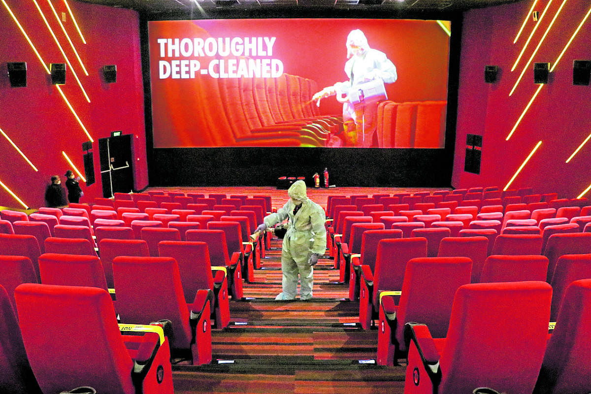 A worker wearing personal protective equipment (PPE) sanitizes seats inside the Inox Leisure movie theatre ahead of its reopening, amidst the outbreak of the coronavirus disease (COVID-19), in Mumbai, India, October 13, 2020. Credit: REUTERS