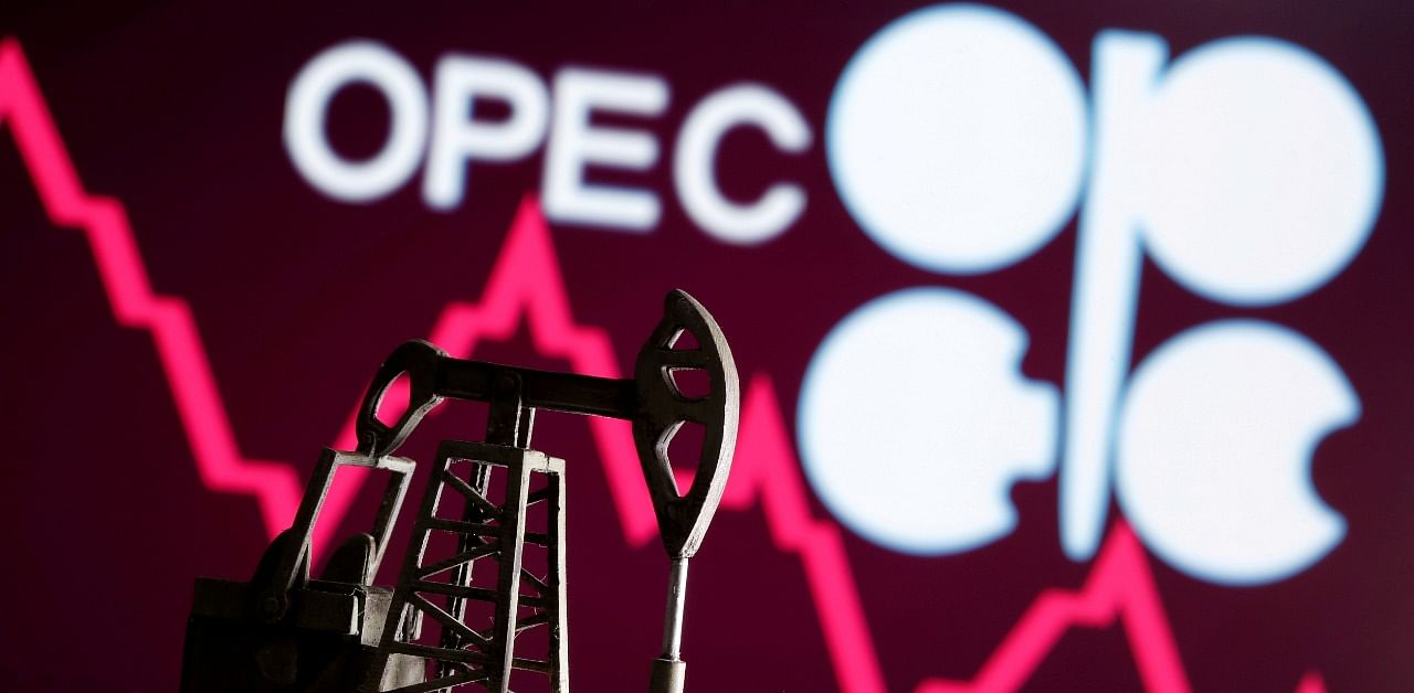 A 3D printed oil pump jack is seen in front of displayed stock graph and Opec logo. Credit: Reuters Photo