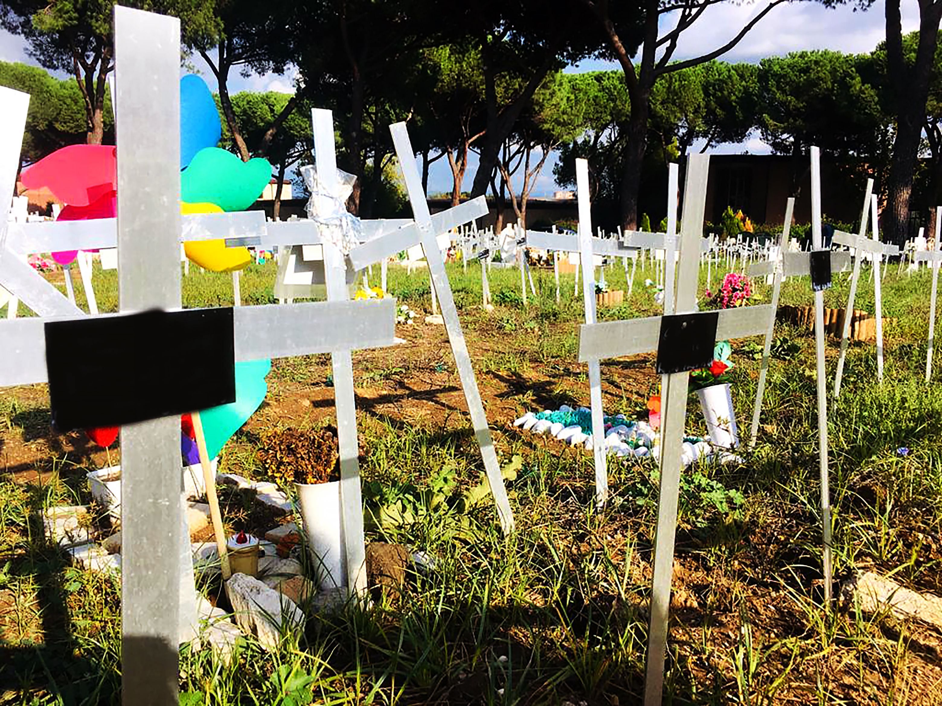 The lot 108 of the Flaminio cemetery in Rome is studded with small wooden and metal crosses, some painted white, others fallen to the ground, but all of which bear the names of women. Credits: AFP Photo