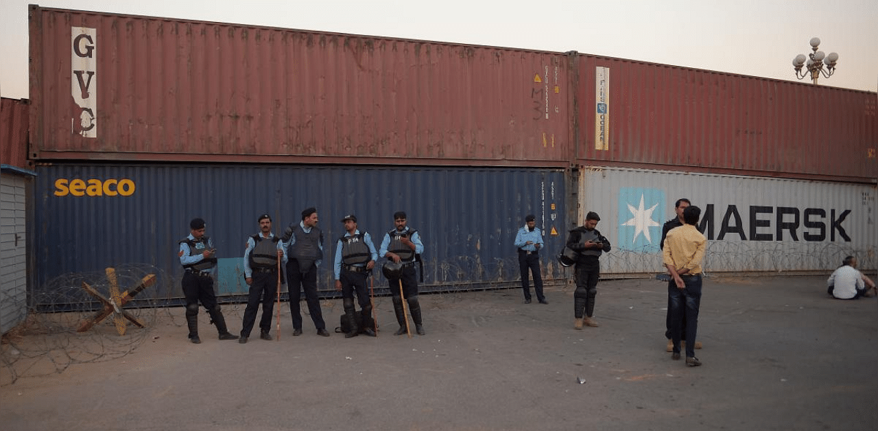 Pakistani policemen stand guard next to coantainer block a road during a union workers' protest against the International Monetary Fund (IMF) and government policies in Islamabad. Credit: AFP Photo