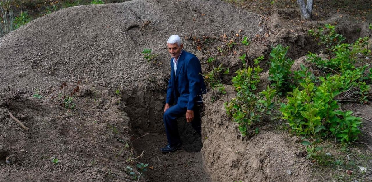 Mikhail Ismailov, one of the few Azerbaijani men who refused to leave the frontline village of Bakharly, near Agdam city, shows his trench for shellings during the ongoing fighting between Armenia and Azerbaijan over the disputed region. Credit: AFP