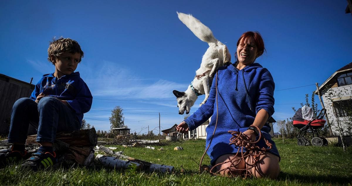 Tatiana plays with their furry pet Plombir. Credit: AFP Photo