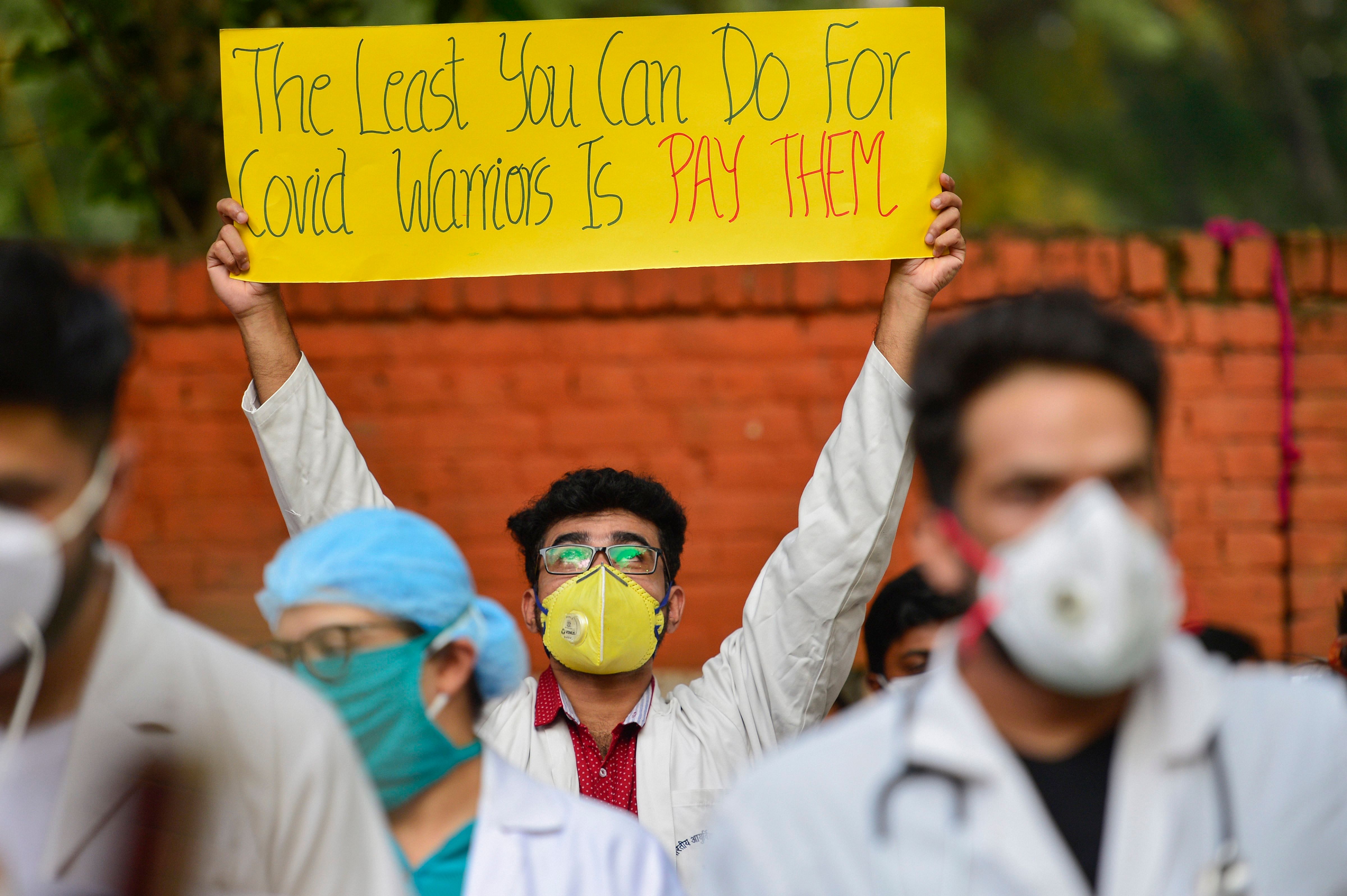 Doctors of Hindu Rao Hospital display placards and shout slogans during a protest against North Delhi Municipal Corporation over non-payment of their pending salaries, at Jantar-Mantar in New Delhi, Friday, Oct. 16, 2020. Credit: PTI Photo