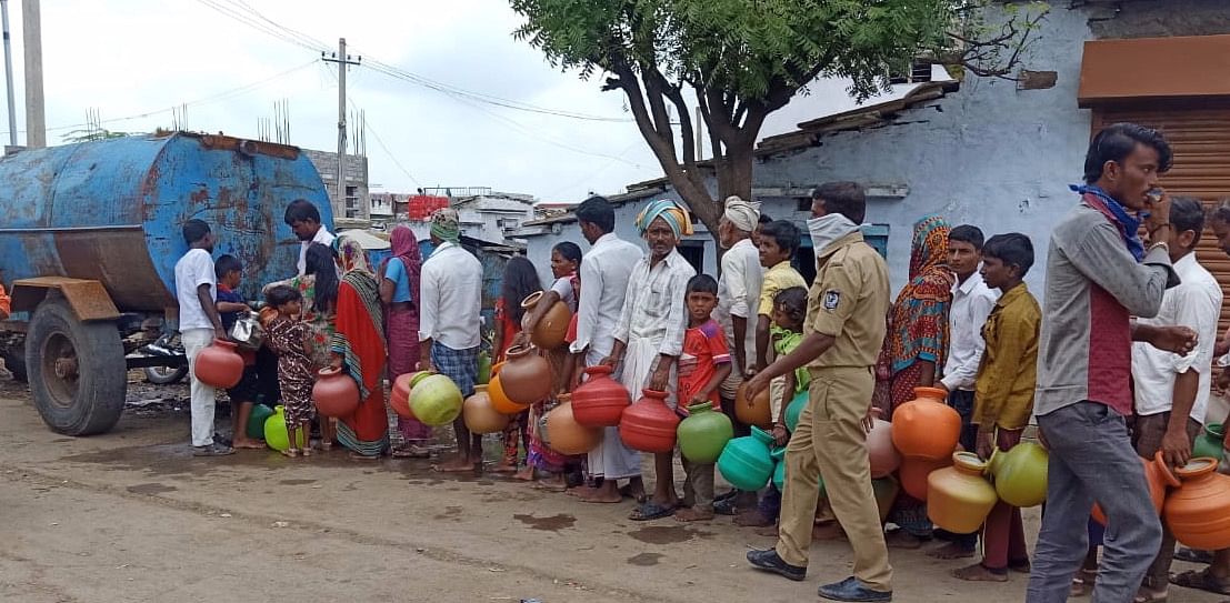 People standing in queue to collect water in Honagunta village in Shahabad taluk of Kalaburagi district. Photo Credit: Gururaj B R