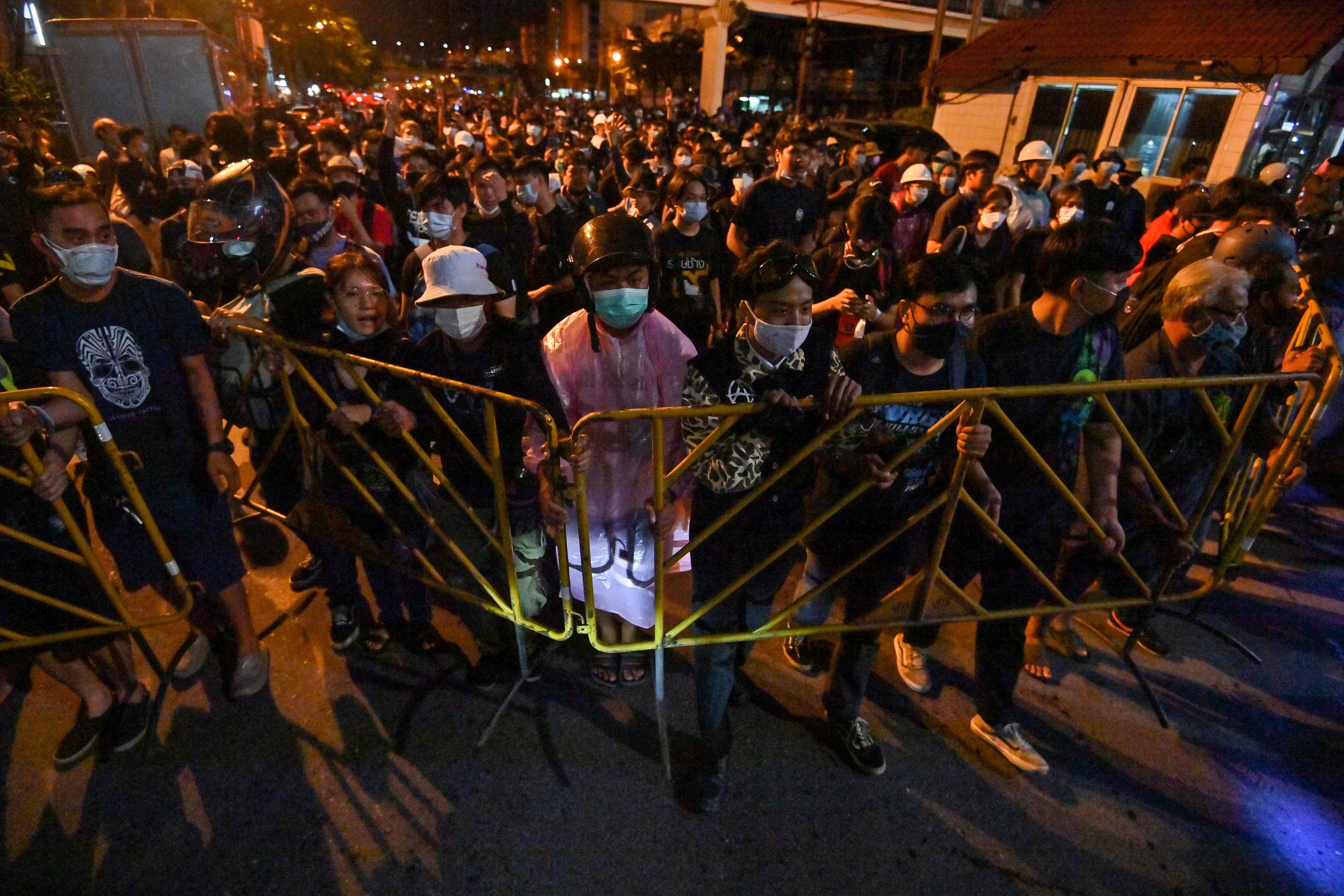 Pro-democracy protesters walk while holding barricades during an anti-government rally at Wongwian Yai in Bangkok. Credits: AFP Photo