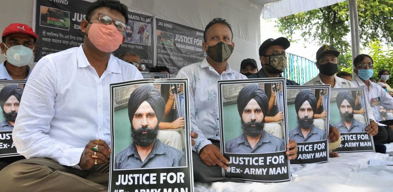 Ex-servicemen and their relatives during a sit-protest near Mahatma Gandhi statue, demanding an immediate release of Balwinder Singh who was arrested in BJP's recent protest rally, in Kolkata. Credit: PTI.