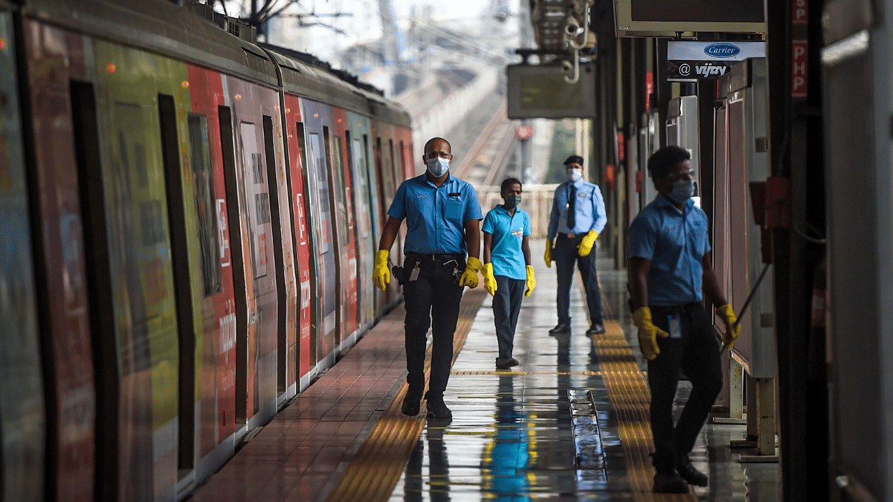 Employees walk on a platform near a train as the metro network prepares to resume services after more than a 6-month shutdown due to the Covid-19. Credits: AFP Photo