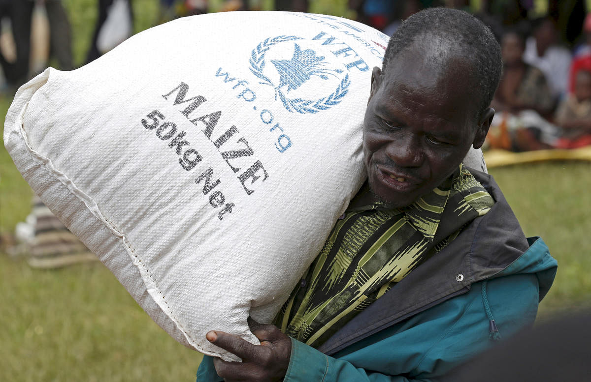 FILE PHOTO: A Malawian man carries food aid distributed by the United Nations World Food Progamme (WFP) in Mzumazi village near the capital Lilongwe, February 3, 2016. REUTERS/Mike Hutchings/File Photo