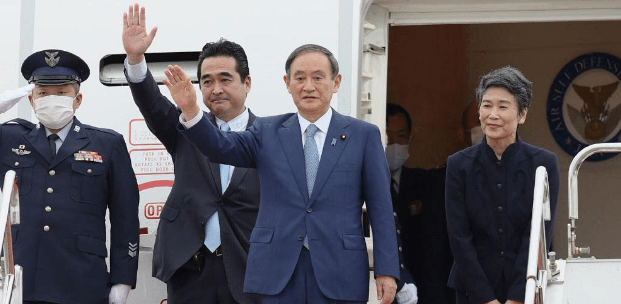 Japanese Prime Minister Yoshihide Suga (C), accompanied by his wife Mariko Suga (R), waves to well-wishers upon his departure at Tokyo's Haneda airport on for a four-day visit to Vietnam and Indonesia. Credit: AFP Photo