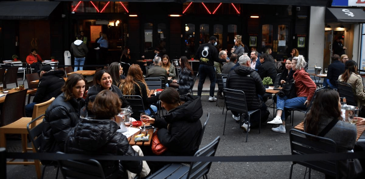 People enjoy their drinks outside at a bar in Soho, in the West End of London amid surge in coronavirus cases. Credit: AFP Photo