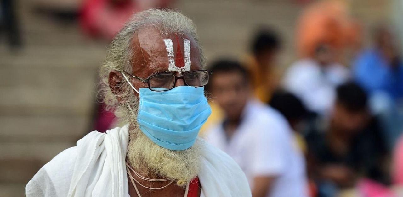 A Sadhu wearing a facemask as a protection against Covid-19, walks at Dasaswamedh Ghat in Varanasi. Credit: AFP.