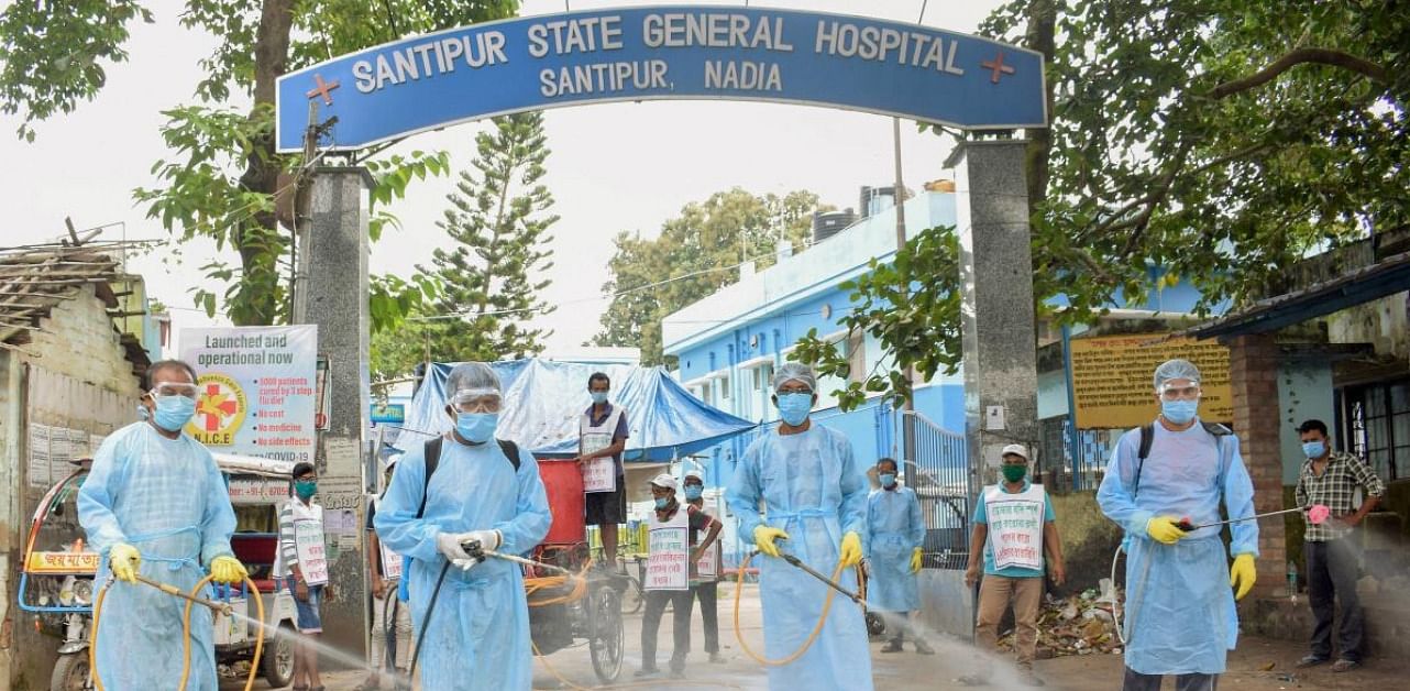 Health workers sanitize outside Santipur State General Hospital amid concerns over Covid-19 outbreak, in Nadia. Credit: PTI.