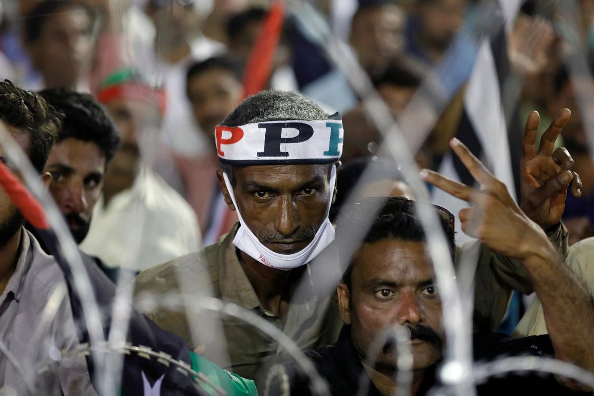 A Pakistan Peoples Party (PPP) supporter listens with others to the leaders' speeches during an anti-government protest rally organized by the Pakistan Democratic Movement (PDM), an alliance of political opposition parties, in Karachi, Pakistan October 18, 2020. Credit: REUTERS