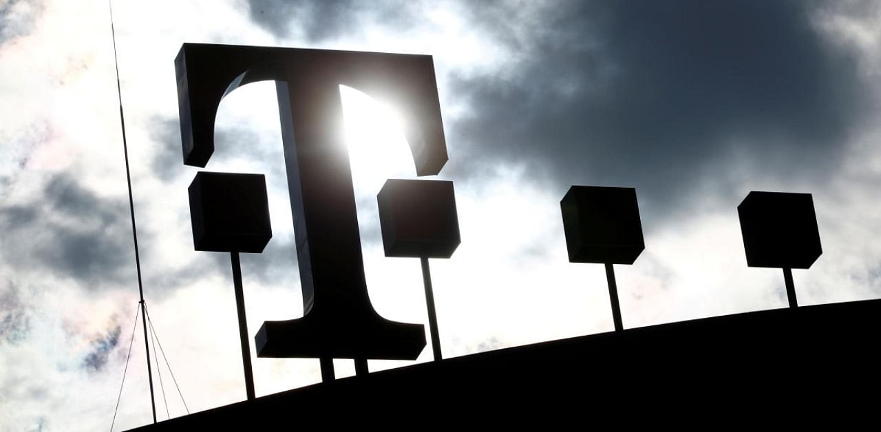 The logo of Deutsche Telekom AG is silhouetted against the sun and clouds atop the headquarters of German telecommunications giant in Bonn. Credit: Reuters.