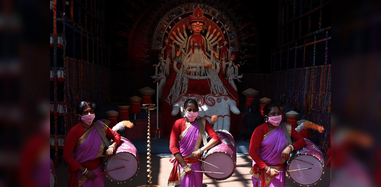 Traditional drummers play perform near an idol of the ten-armed Hindu Goddess Durga at a makeshift place for worship ahead of the Hindu festival 'Durga Puja' in Kolkata on October 20, 2020. Credit: AFP Photo