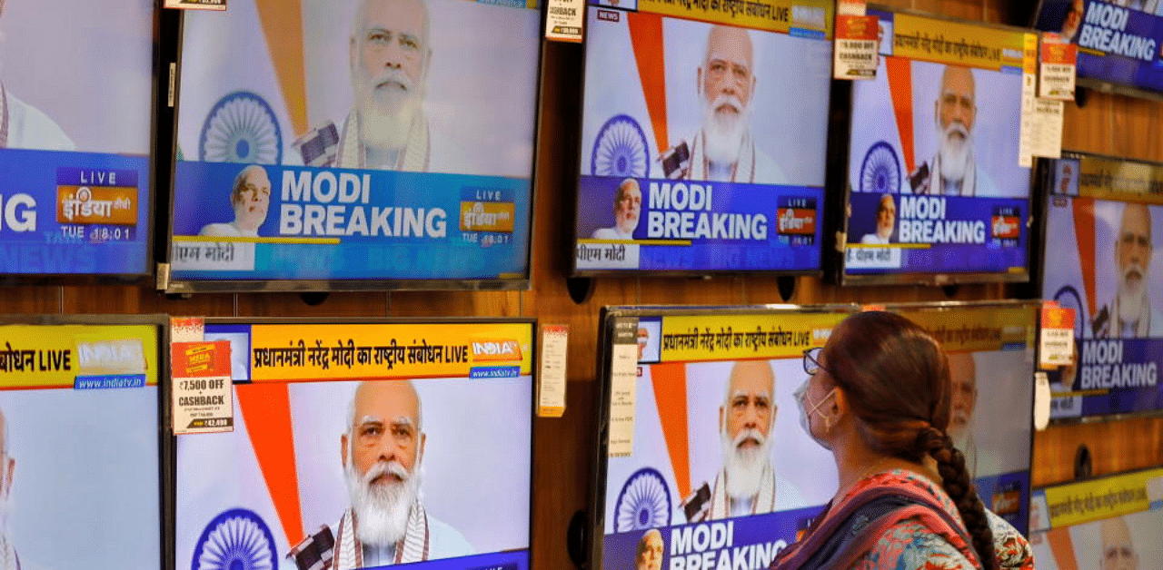 A woman wearing a protective mask watches Indian Prime Minister Narendra Modi on TV screens inside a showroom, amidst the spread of the coronavirus disease (COVID-19), in Ahmedabad, India, October 20, 2020.  Credit: Reuters Photo
