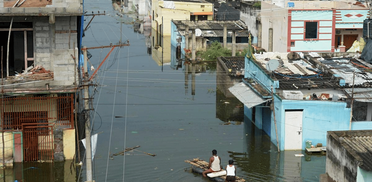 Flood-affected residents ride on a float through a flooded housing colony in search of their belongings following heavy rains on the outskirts of Hyderabad. Credit: AFP Photo